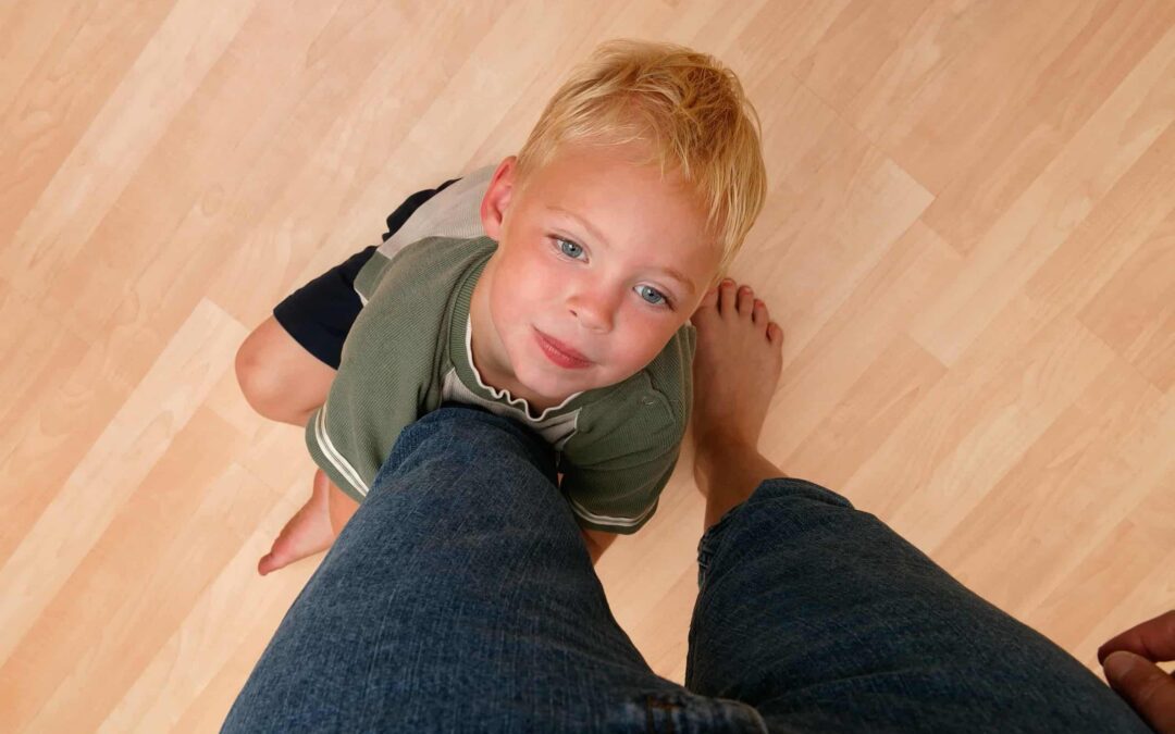 child holding on to mothers leg