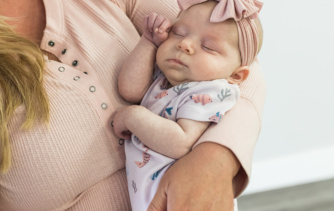 A Baby being held in a women's arms